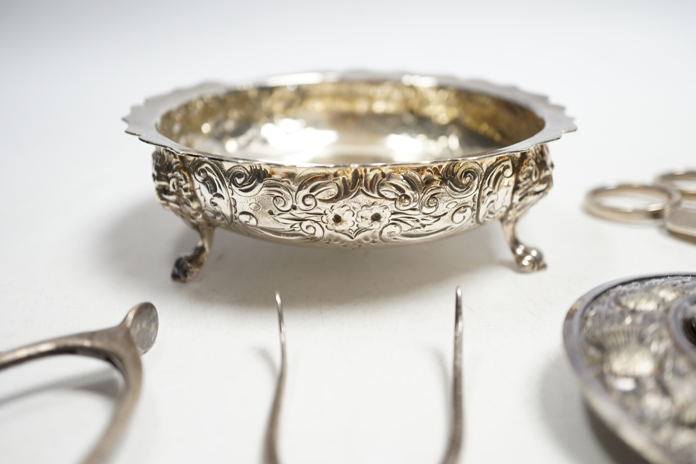 A pair of George V silver grape shears, Mappin & Webb, Sheffield, 1935, 17.2cm, four assorted pairs of early to mid 20th century silver wish bone sugar nips, a plated bowl and a brooch.